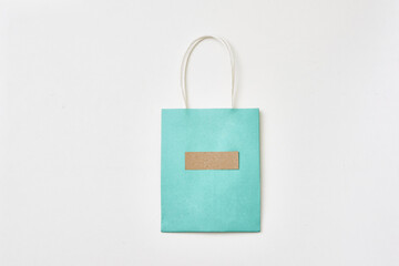 Gift blue paper bag on a white background. Copy space, flat lay, mock up, top view