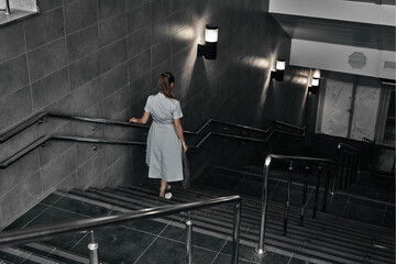 Fototapeta na wymiar Girl on the stairs down, late transition, subway. One person on the descent into the underpass.