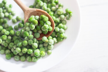 green peas in a white plate on a white background