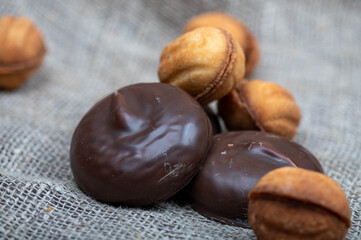 Chocolate cakes and homemade cookies on a background of coarse homespun fabric. Close-up, selective focus.