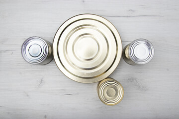 Various closed tin cans with food preserves on a light background. Canned food concept. Food donations. Copy space.