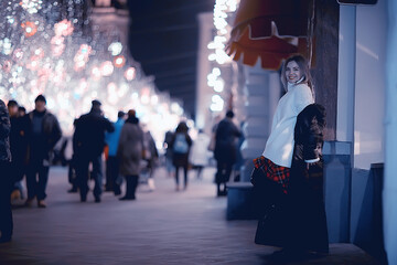 girl christmas lights evening decorated city, a young model on the background of urban decorations and garlands, night city lights