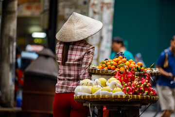Woman at the street market of Hanoi in Vietnam - obrazy, fototapety, plakaty