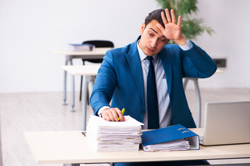 Young male employee unhappy with excessive work in the office