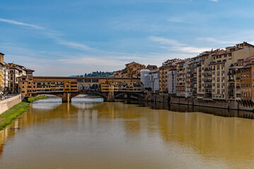 Naklejka premium The Ponte Vecchio reflecting on the water of the Arno River at the old town of Florence, Tuscany Region in Italy 