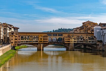The Ponte Vecchio reflecting on the water of the Arno River at the old town of Florence, Tuscany Region in Italy 