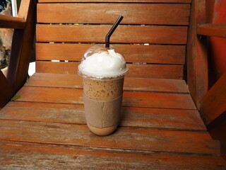Glass of coffee on wooden chair