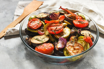 Roasted vegetables mix on plate on a concrete background