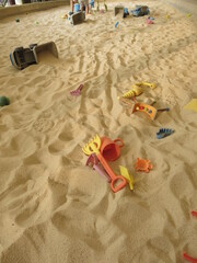 there are many trunks full of sand and all kinds of toys in the Children's bunker  for the joyful concept of sandpit 