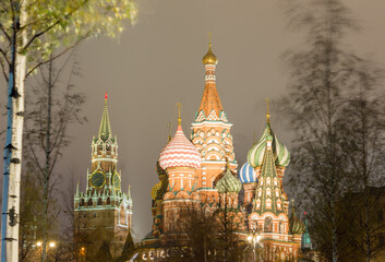 Fototapeta na wymiar Moscow, Russia, Kremlin. St. Basil's catherdral and Spasskaya tower in night. View from Zaryadye park. Trees swaying in the wind