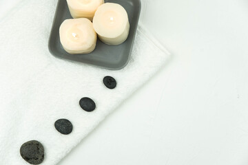 Obraz na płótnie Canvas Gray zen pebble hot stones with towel on massage table in beauty salon. Hot stone massage setting. Concept set of harmony, balance and meditation, spa, relax, spa treatment