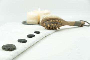 Gray zen pebble hot stones with towel and wooden massager on massage table in beauty salon. Hot stone massage setting. Concept set of harmony, balance and meditation, spa, relax, spa treatment