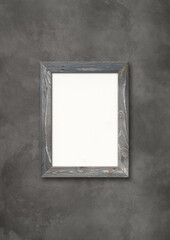 Old rustic wooden picture frame hanging on a concrete wall