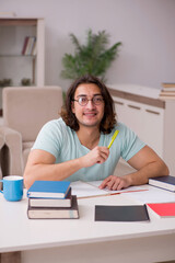 Young male student preparing for exams at home