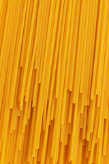 Uncooked dried spaghetti pasta on yellow background. Top view. Vertical Full Frame photo.