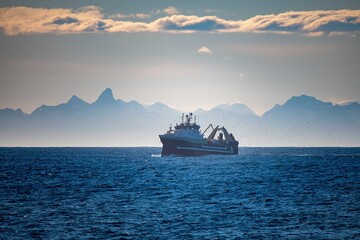 fishing vessel in front of mountain background