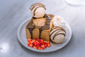 Blurred background view Of the dessert menu (Honey Toast) that contains ice cream, whipped cream, sour fruit like strawberries to be decorated and served to the customer.