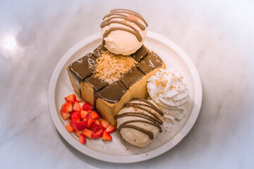 Blurred background view Of the dessert menu (Honey Toast) that contains ice cream, whipped cream, sour fruit like strawberries to be decorated and served to the customer.
