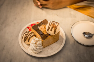Blurred background view Of the dessert menu (Honey Toast) that contains ice cream, whipped cream, sour fruit like strawberries to be decorated and served to the customer.