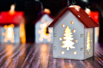 Small Christmas houses with Christmas tree windows that glow from the inside. Christmas garland in the form of houses with illuminated windows at night. Christmas background, postcard, place for text