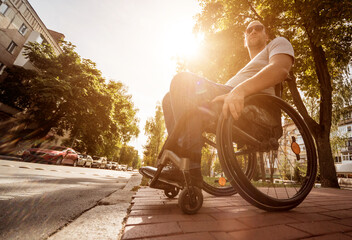 Handicapped man in wheelchair preparing to cross the road on pedestrian crossing