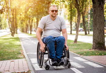 Fototapeta na wymiar Handicapped man in wheelchair walk at the park alley