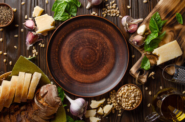 Flat lay view at food background of genovese pesto sauce ingredients on wooden kitchen table with copy-space