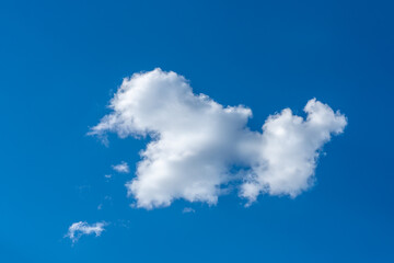 White cloud in sunlight on a clear blue summer sky