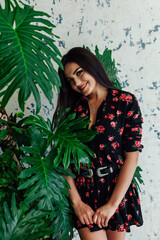 Portrait of a beautiful fashionable woman in a black dress with flowers