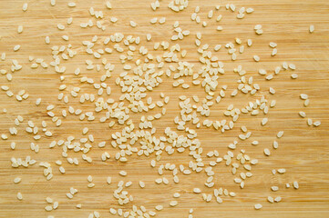 Fresh organic white raw rice grains texture, on bamboo cutting board