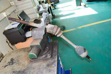 The right drive shaft of the car is clamped in a vise