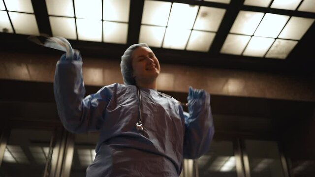 Female surgeon takes off medical mask and dances during night shift
