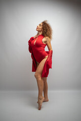 curly girl in red clothes on a white background in a photo studio