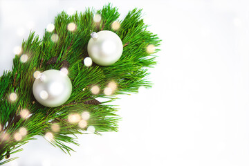 Fototapeta na wymiar White balls and green pine branches close up with bokeh on white background. Christmas or New Year holiday greeting card