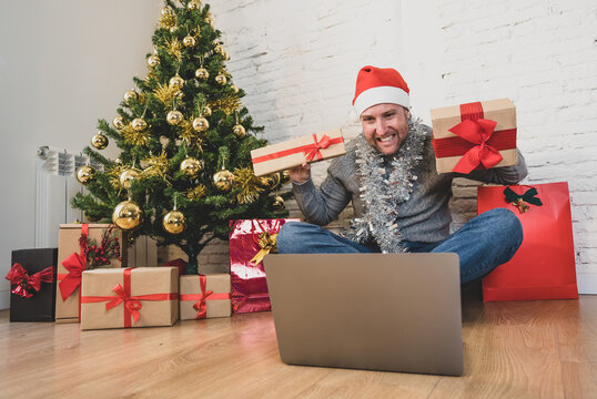 Happy man on video call celebrating virtual christmas with family online at home in lockdown