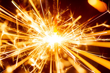 Sparks from Christmas sparklers on black background, big bang, fire and danger, selective focus,...