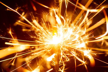 Sparks from Christmas sparklers on black background, big bang, fire and danger, selective focus,...