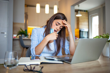 Woman holding her mask after taking it off. Woman Removing mask from face. Woman with a protective face mask having breathing troubles during the COVID-19 pandemic.