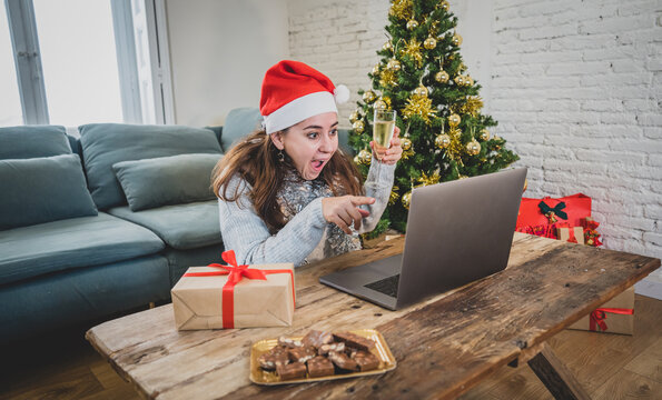 Happy woman on video call celebrating Virtual christmas with family online at home in lockdown