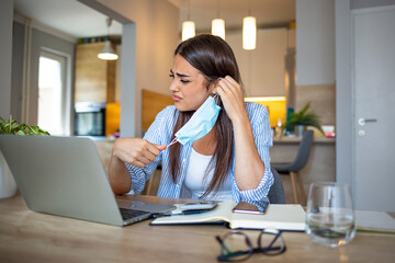 Woman Removing mask from face.  Woman with a protective face mask having breathing troubles. Risk coronavirus 2019-ncov contamination at workplace concept