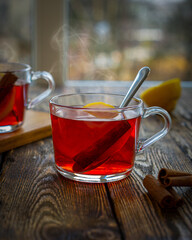 Cup of red tea with cinnamon and lemon in autumn mood.