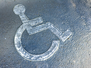 Disabled icon on a wet asphalt.