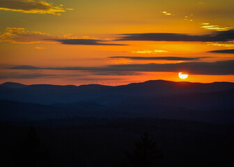 Fototapeta na wymiar Orange sunset over wind turbine mountains Mount Olga Wilmington Vermont Nov. 2020