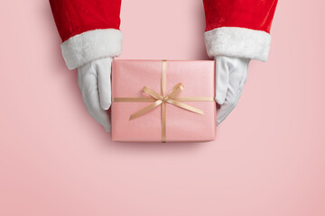 Top view of Santa claus hands is holding a pink gift box