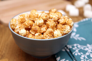 Sweet popcorn in a bowl on the desktop in the kitchen