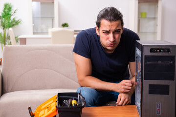 Young man repairing computer at home