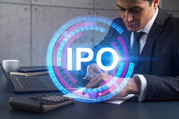 A man in office taking notes using phone and ipo theme hologram. Multiexposure. Formal wear. Invest in stock market.