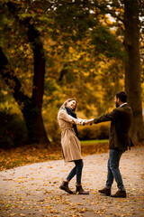 Fototapeta premium Young couple having fun in the autumn park