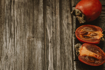 persimmon and persimmon slices on a wooden table 