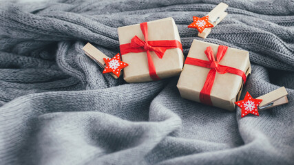 Christmas gift boxes and New Year decorations on cozy gray sweater.